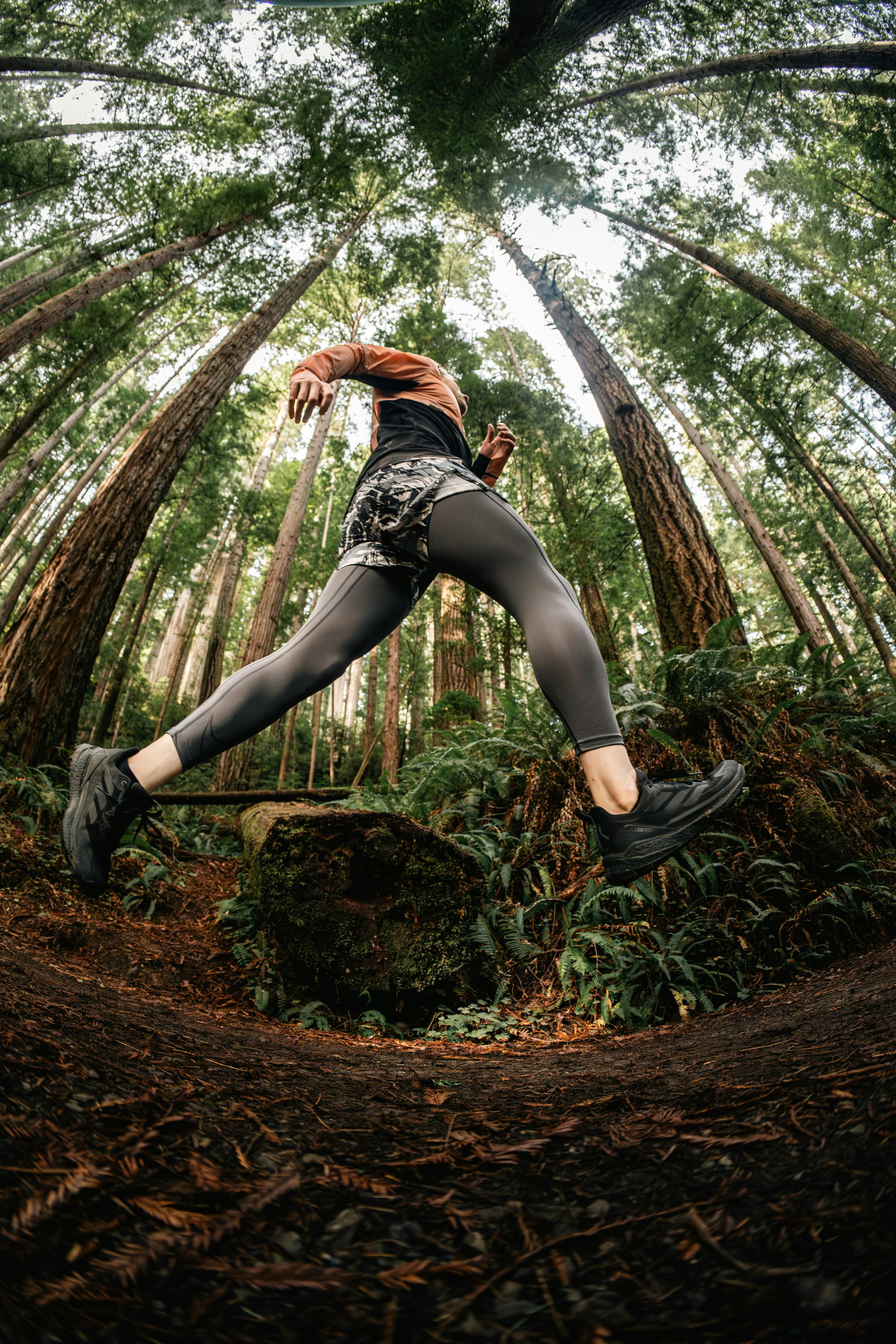 Traileur en plein saut sur un single track en forêt