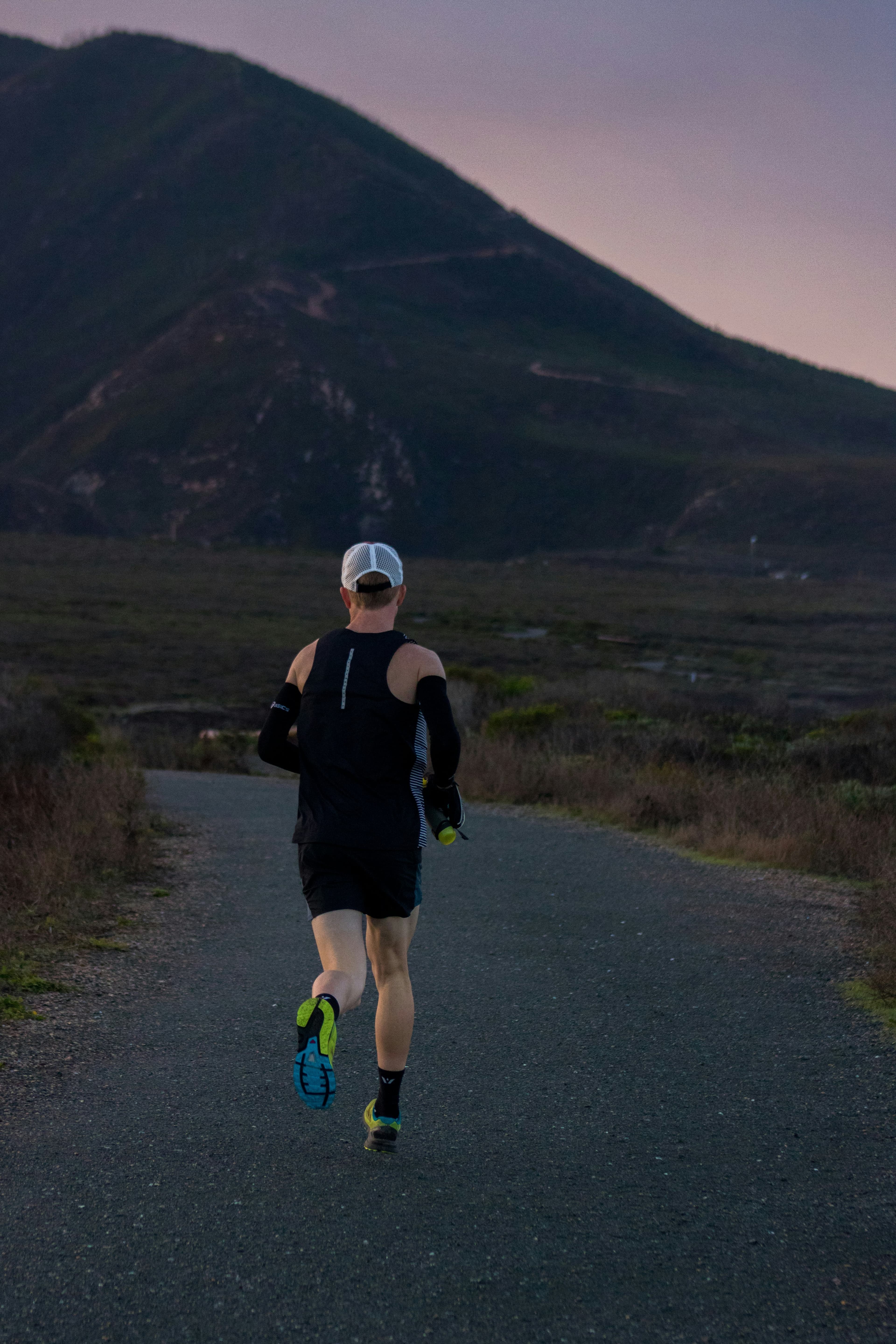 Coureur de dos face à la montagne au lever du jour
